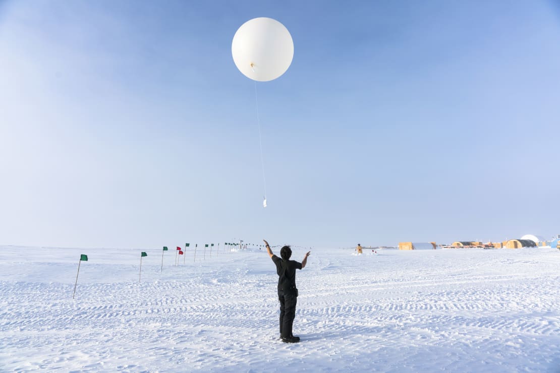 Winterover having just let go to launch a weather balloon.