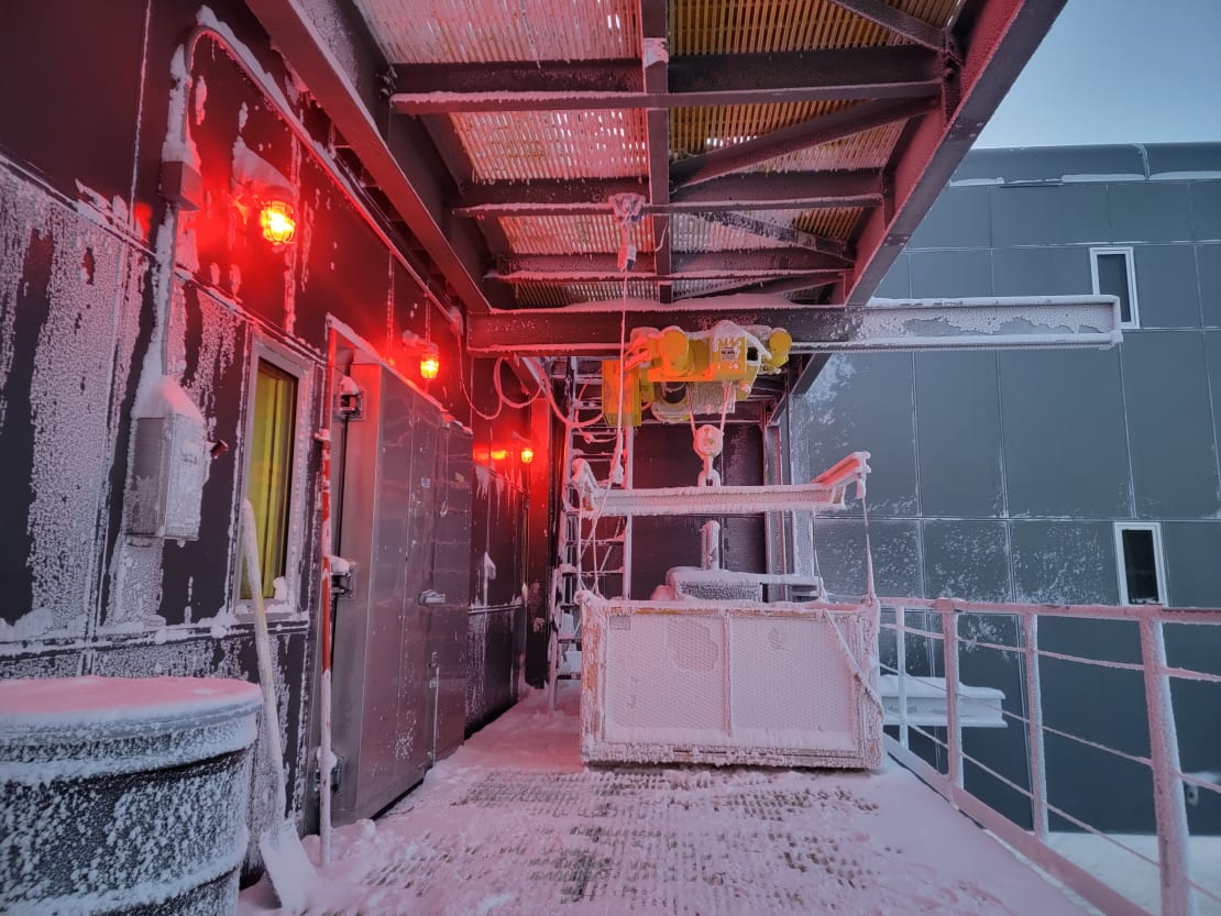 Frosty exterior platform of South Pole station seen in waning daylight.