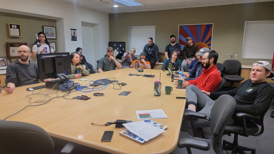 People gathered around the conference room table at the South Pole station.