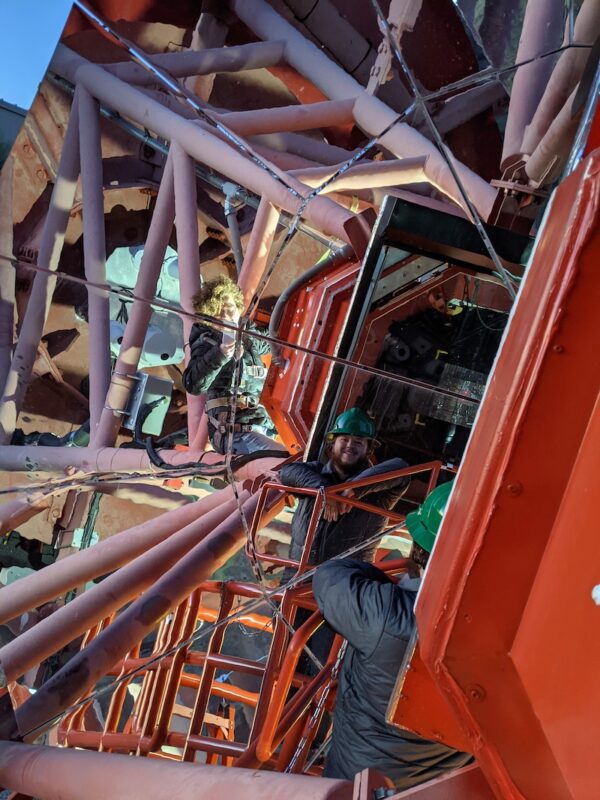 A man and a woman taking a selfie in front of the pSCT telescope mirror