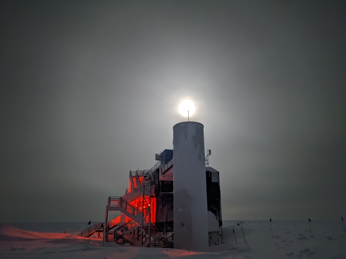 Full moon and cloudy sky over side view of the IceCube Lab.