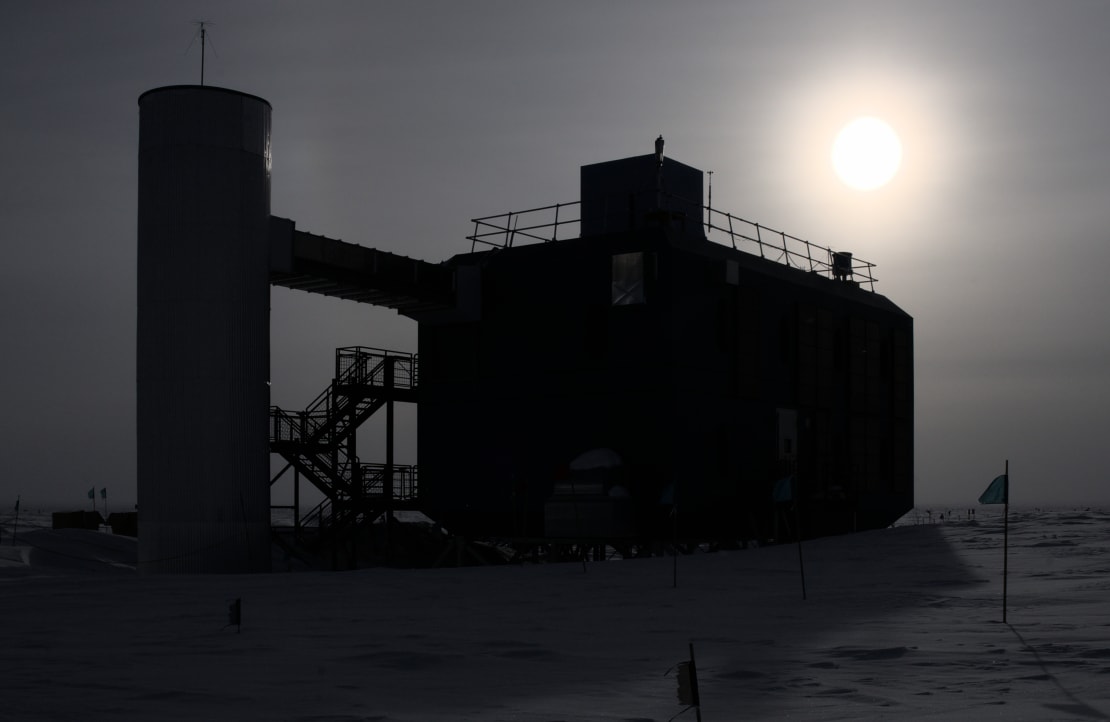 The IceCube Lab in shadow in front of the low sun.