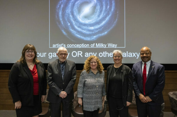 A group of people posing in front of a screen