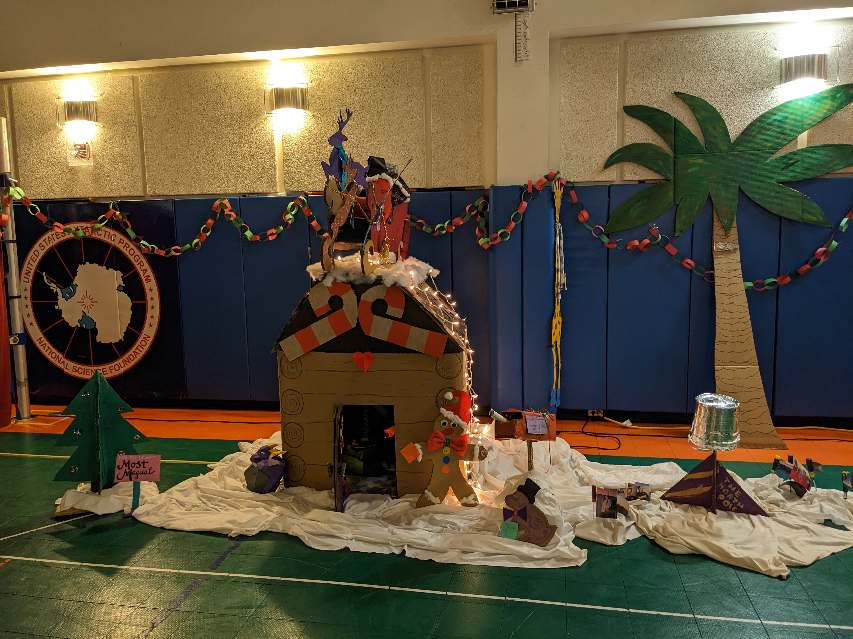 Cardboard “Santa house” and other decorations set up in South Pole gym, neat and tidy before party.