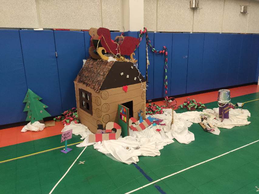 Cardboard “Santa house” and other decorations set up in South Pole gym, a bit in disarray after party.