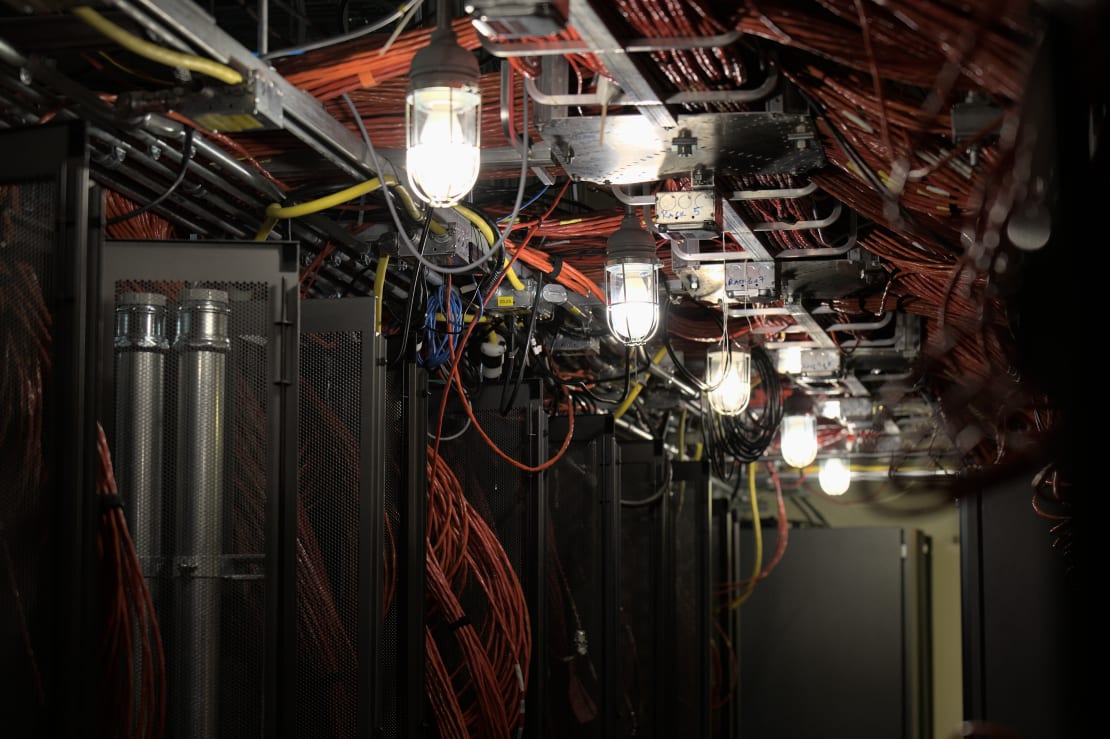 Inside view of IceCube Lab server room, with lots of orange cables between racks of servers.