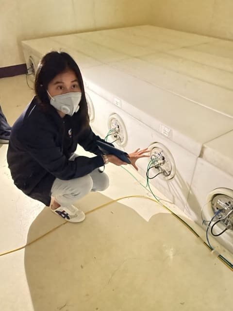 A woman with a mask sitting in front of the Princess Sirindhorn Neutron Monitor