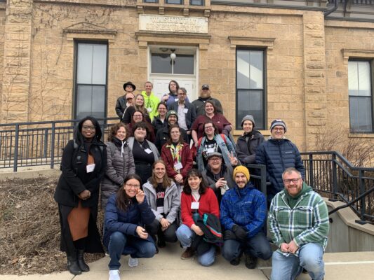 A group of people posing in front of a building